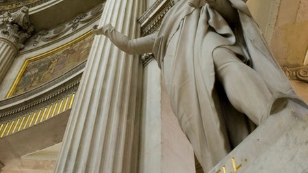 A stone statue set within a grand rotunda framed with columns