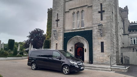 A Top Hat Chauffeurs car parked outside Cabra Castle Hotel