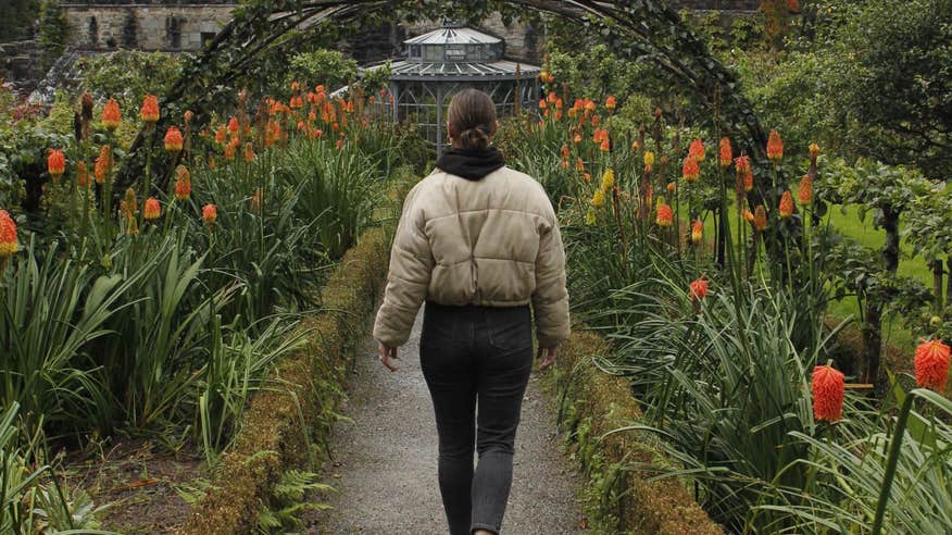 Sarah Hanrahan walking down a flower lined path in Glenveagh National Park, Donegal