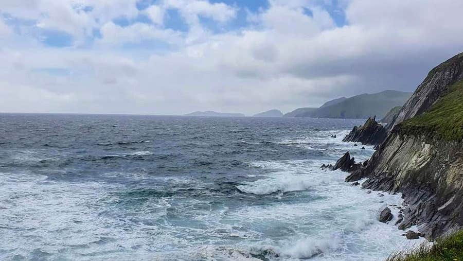 A view of the sea with foamy waves crashing against some high rocks