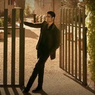 A man is swinging from a large gate