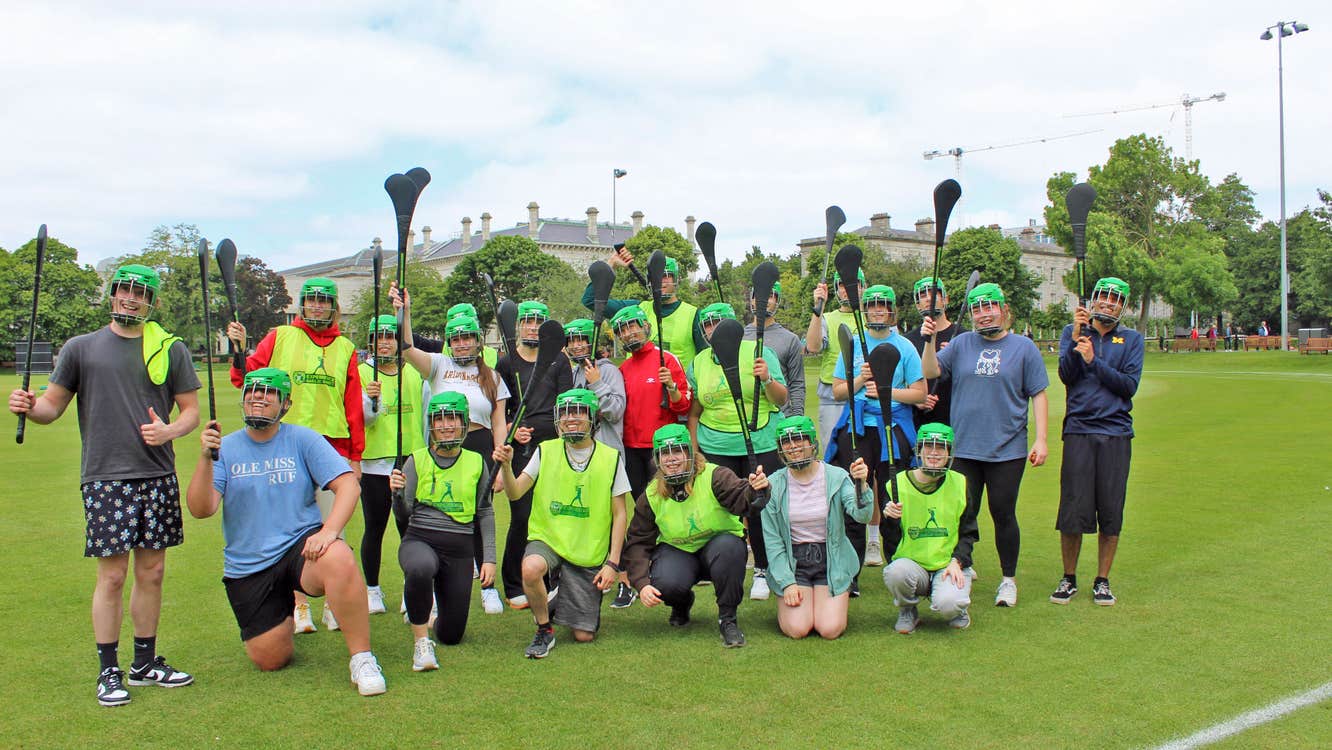 Experience Gaelic Games group in a field with hurleys