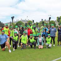 Experience Gaelic Games group in a field with hurleys