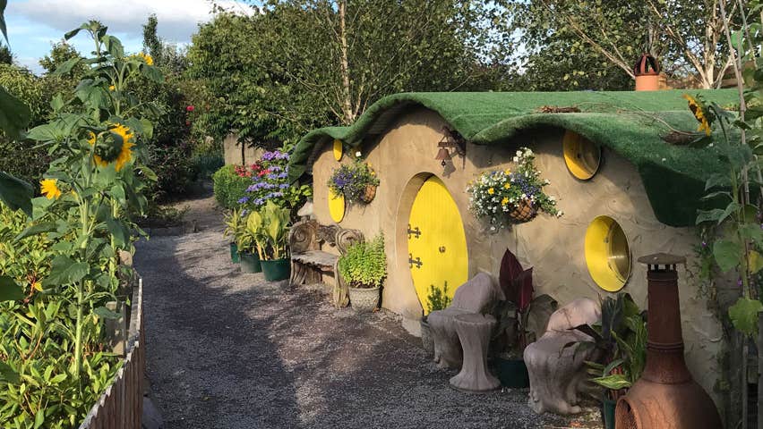 A row of round fairy houses surrounded by shrubs and flowers at Glenview Gardens in County Cork