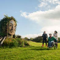 Three people receiving a tour of Hill of Uisneach in County Westmeath.