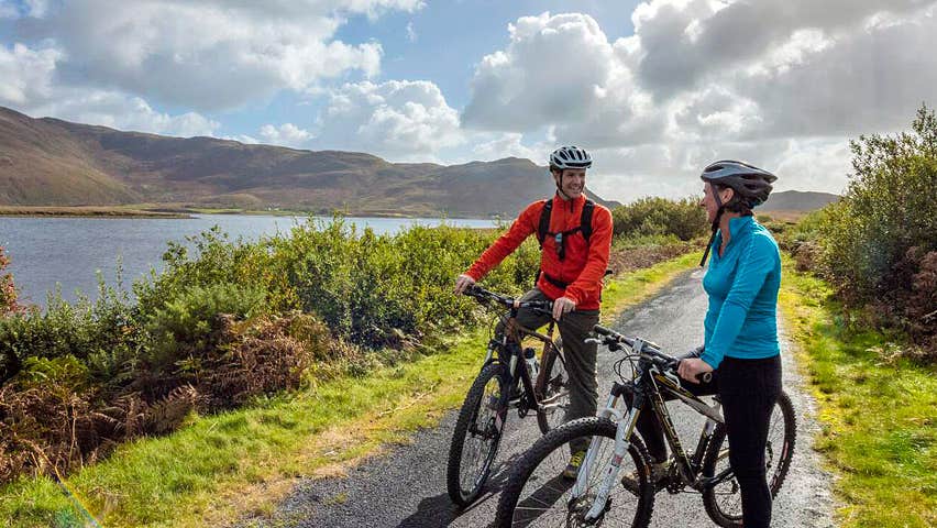 Clew Bay Bike Trail with two cyclists next to the bay and mountains
