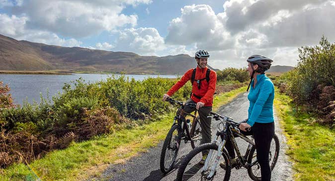 Clew Bay Bike Trail with two cyclists next to the bay and mountains