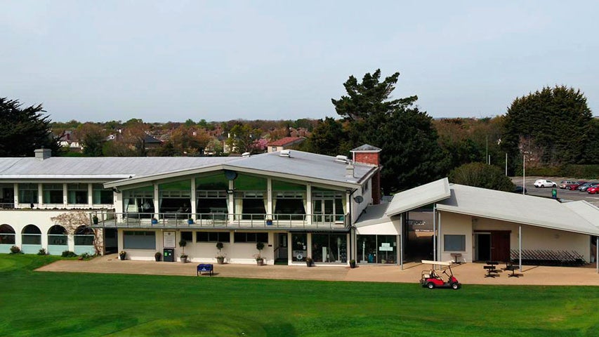 Exterior of the clubhouse from a height with a red golf buggy outside