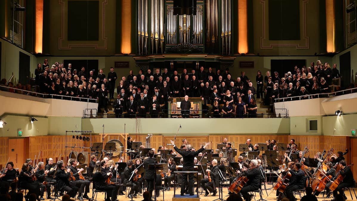 NSCI – 40th Anniversary Celebration - view of a large stage with orchestra and a choir on balcony above the stage.