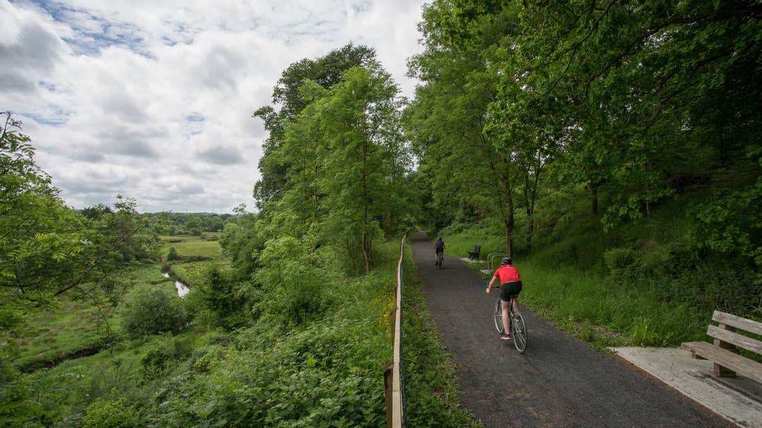 Two people cycling along a path on the Limerick Greenway, Limerick