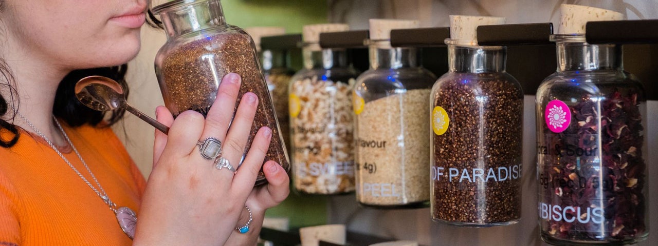 A lady smelling from the jar of the botanicals used to make the gin at Stillgarden Distillery