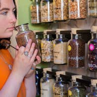 A lady smelling from the jar of the botanicals used to make the gin at Stillgarden Distillery
