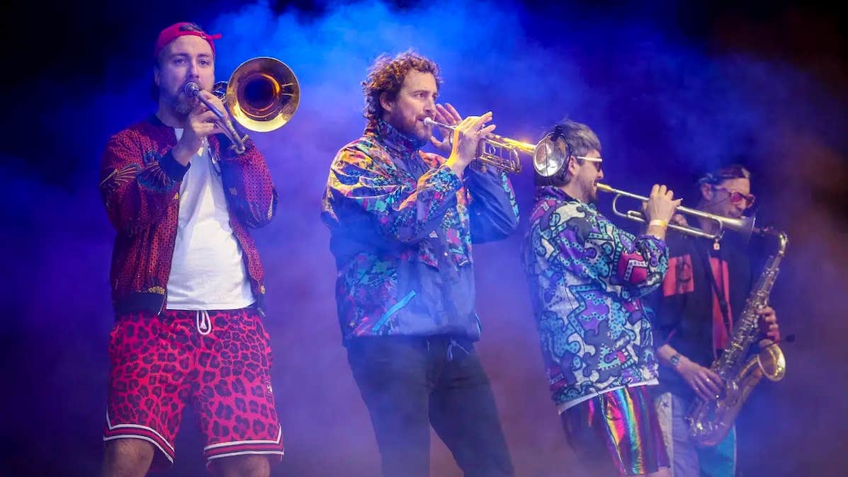 4 musicians playing brass instruments on a hazy stage