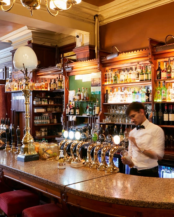 Man pouring a pint at a bar.