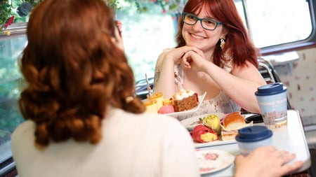 Two ladies with red hair chatting over afternoon tea
