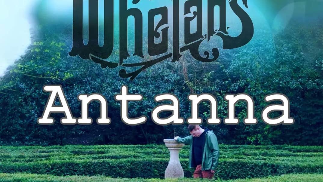 A man resting arm on tall garden stone ornament standing in a hedge garden