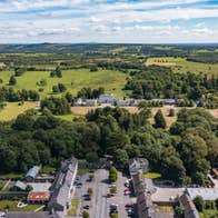 Aerial view of a woodland and period buildings