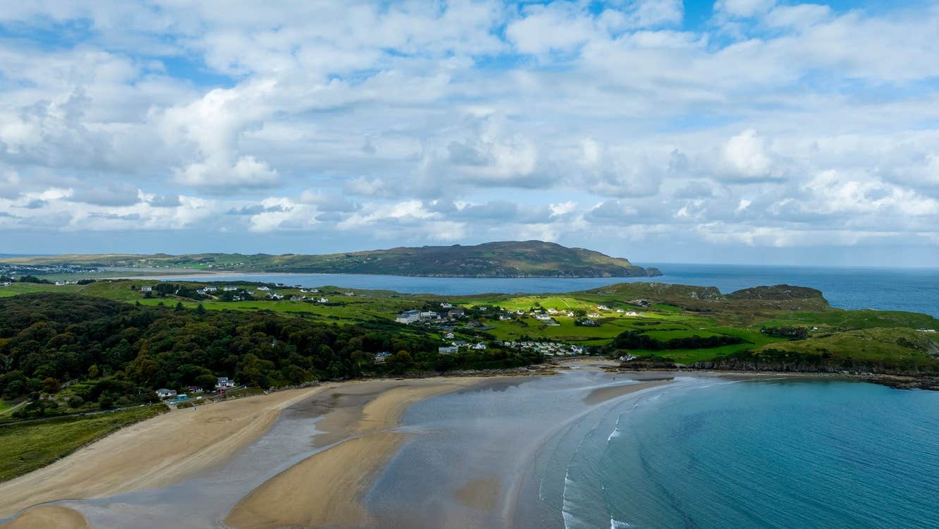 An aerial view of a beach with the tide going out