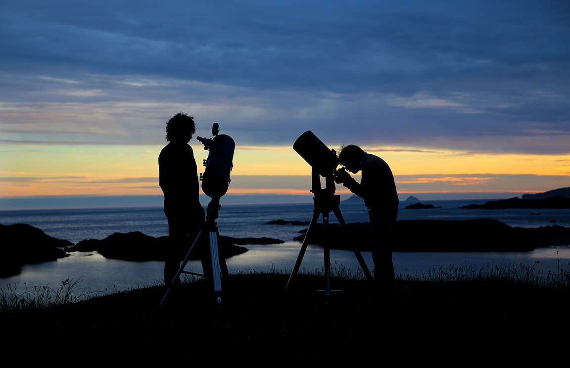 Two people looking up at the sky through telescopes in Dark Sky Park, Kerry