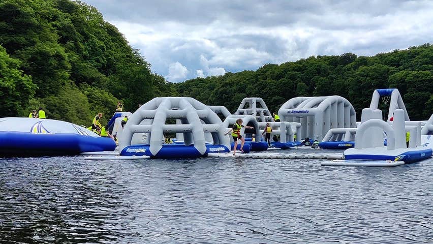 A floating obstacle course on a lake with people on it