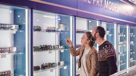 A couple looking at the displays of the model trains