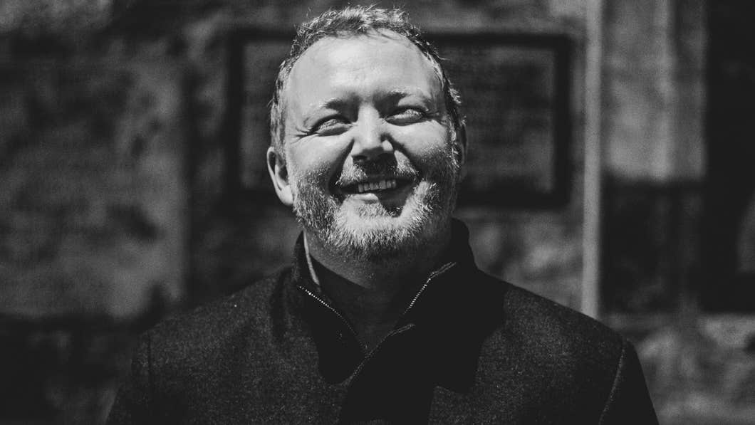 Smiling man in dark coat outdoors