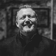 Smiling man in dark coat outdoors