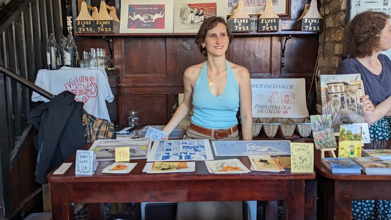 A lady standing at her stall selling t-shirts