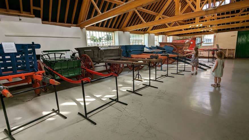 Two kids looking at old carts on display at the Irish Agricultural Museum in County Wexford.