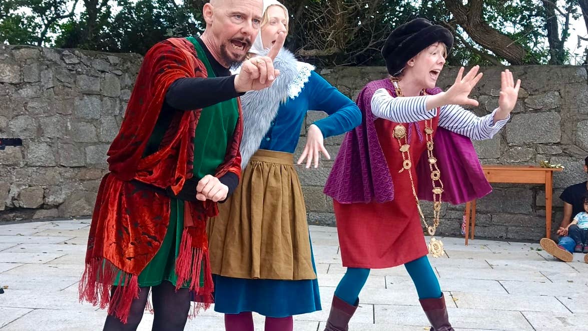 Bloomsday for Kids: The Cat and the Devil - 3 people in colourful costumes performing in a paved area.