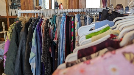 Some clothing rails with vintage clothes for sale at a market