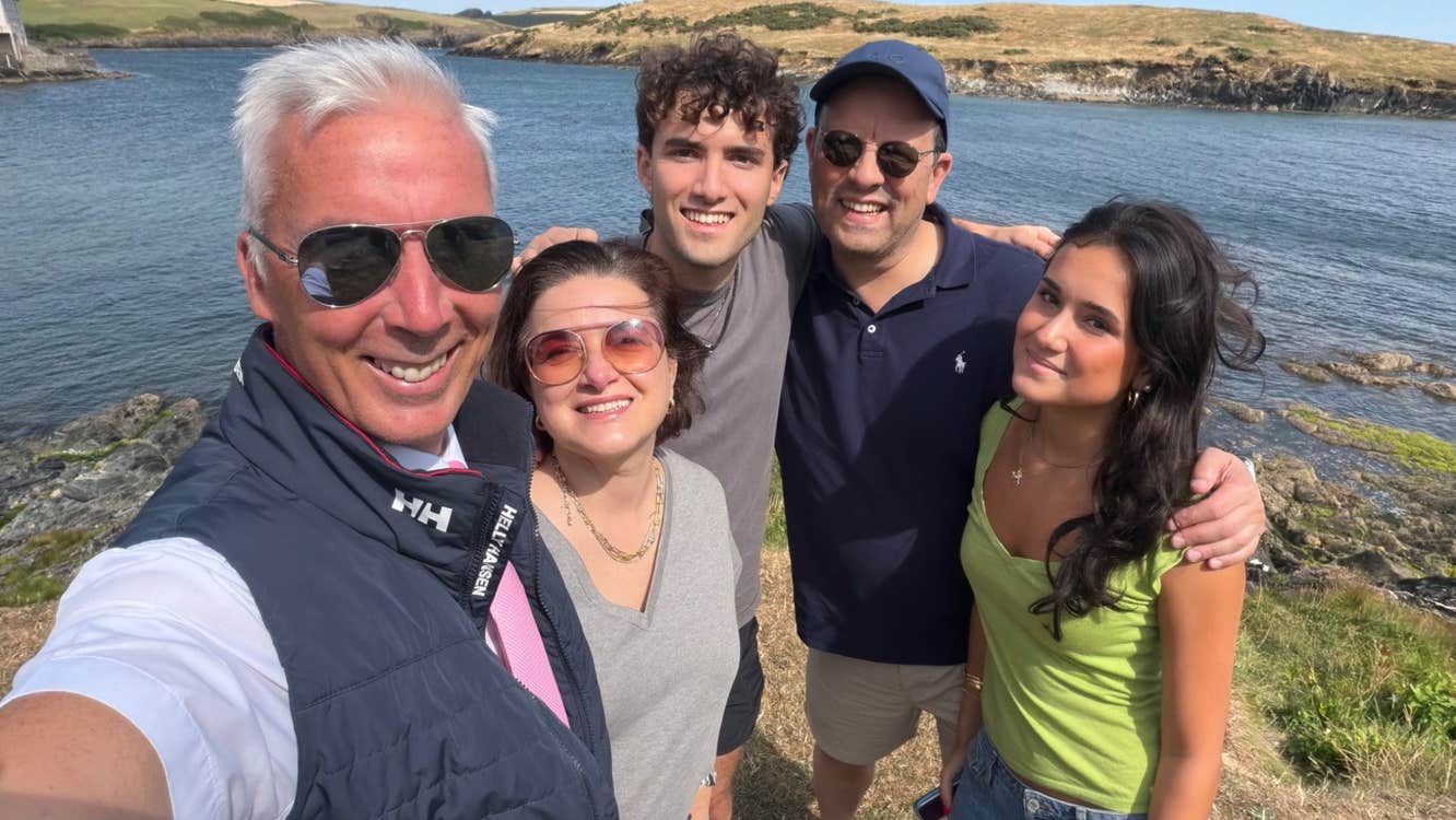 Private Tours Cork driver standing with guests for a photograph by a rocky shoreline