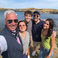 Private Tours Cork driver standing with guests for a photograph by a rocky shoreline
