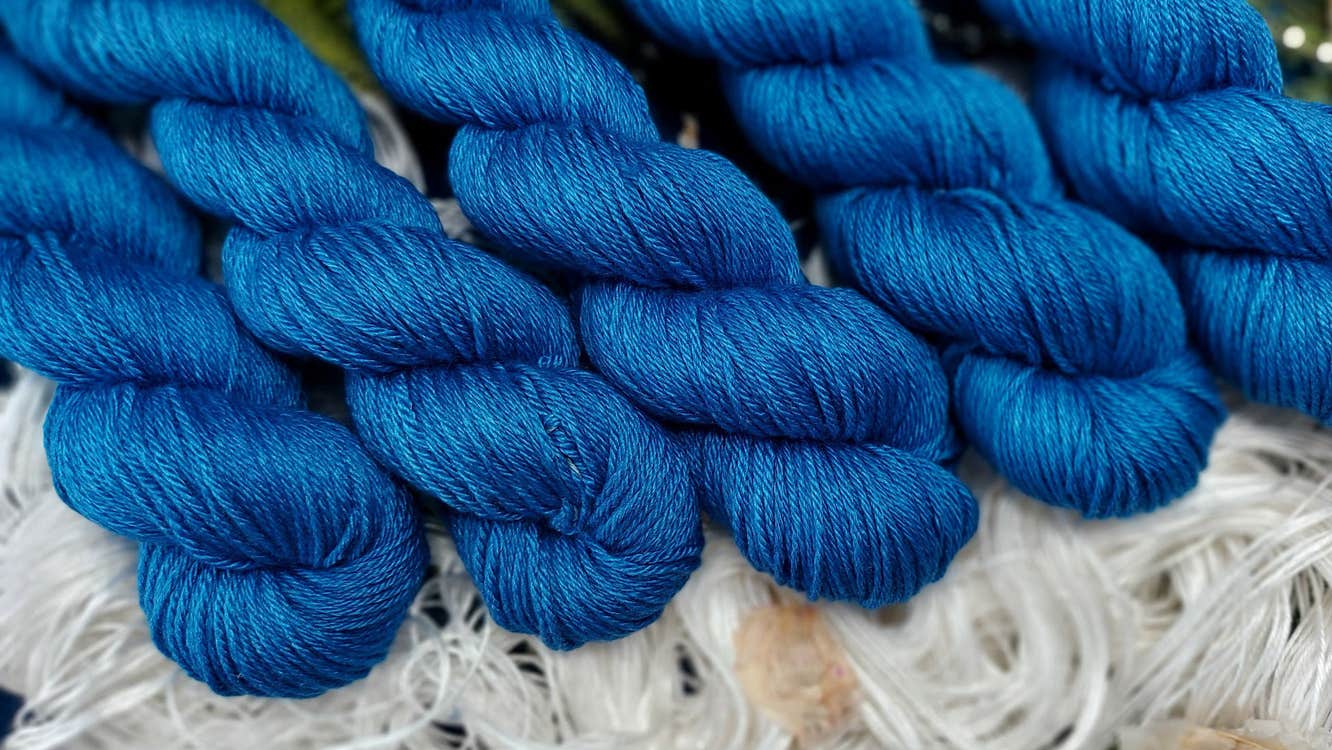 Skeins of blue yarn laid out over white yarn