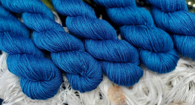 Skeins of blue yarn laid out over white yarn