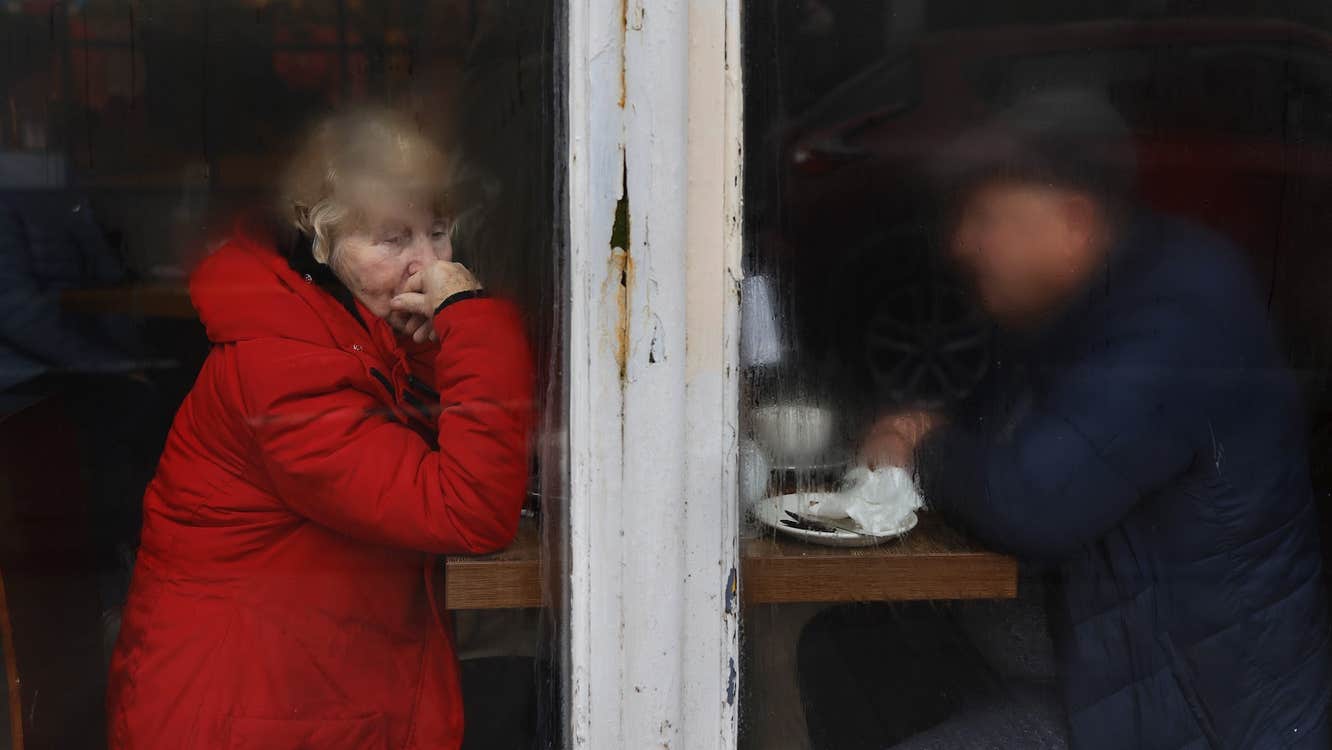 Elderly couple sitting on other side of window, half fogged, drizzly morning, man obscured by condensation and woman stares out of frame to the bottom right. Copyright David Stephenson.