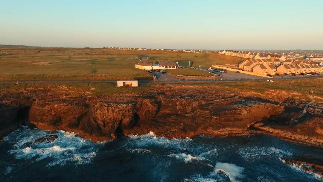 Waves crashing against cliffs at sunset