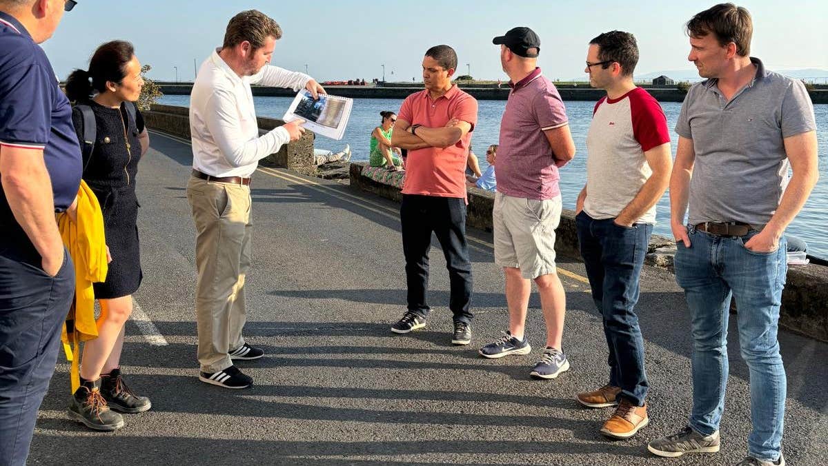 A group of people standing beside the water