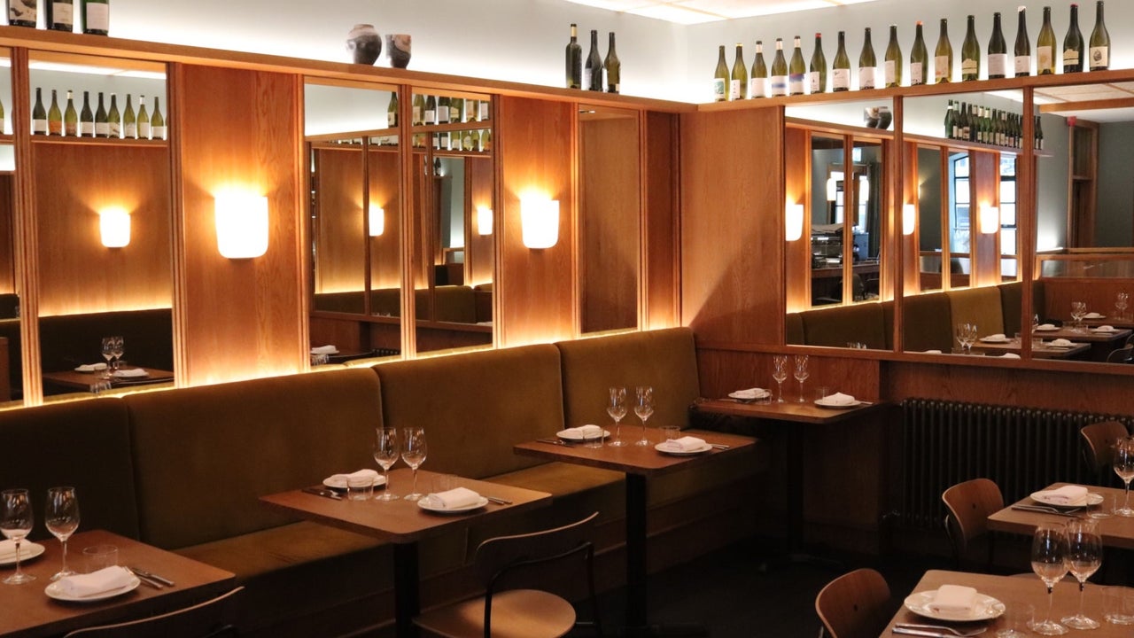 The dining area at Comet with wood panel and mirrors on the walls dim lighting