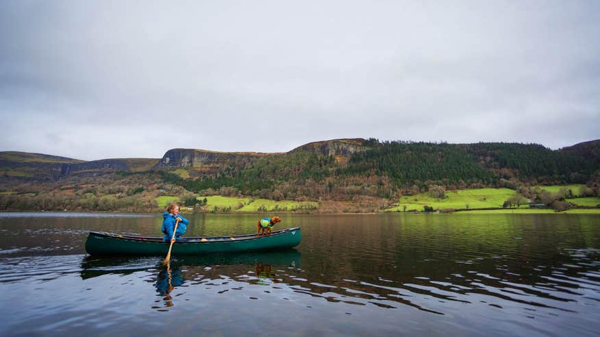 Woman and a dog on a canoe in Glencar Lake, Leitrim