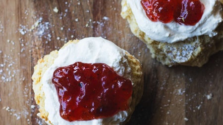 Homemade scones with cream and a dollop of jam on top