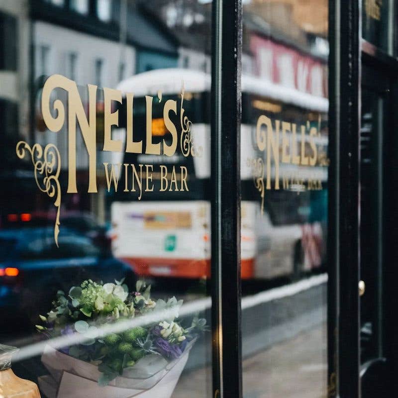 Nell's Wine Bar, front window with the restaurant name in gold printed across the glass.