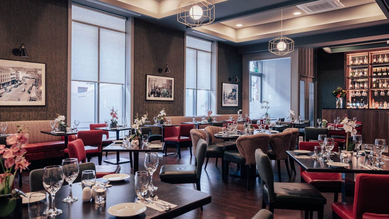 An empty hotel restaurant with prepared tables ready for diners