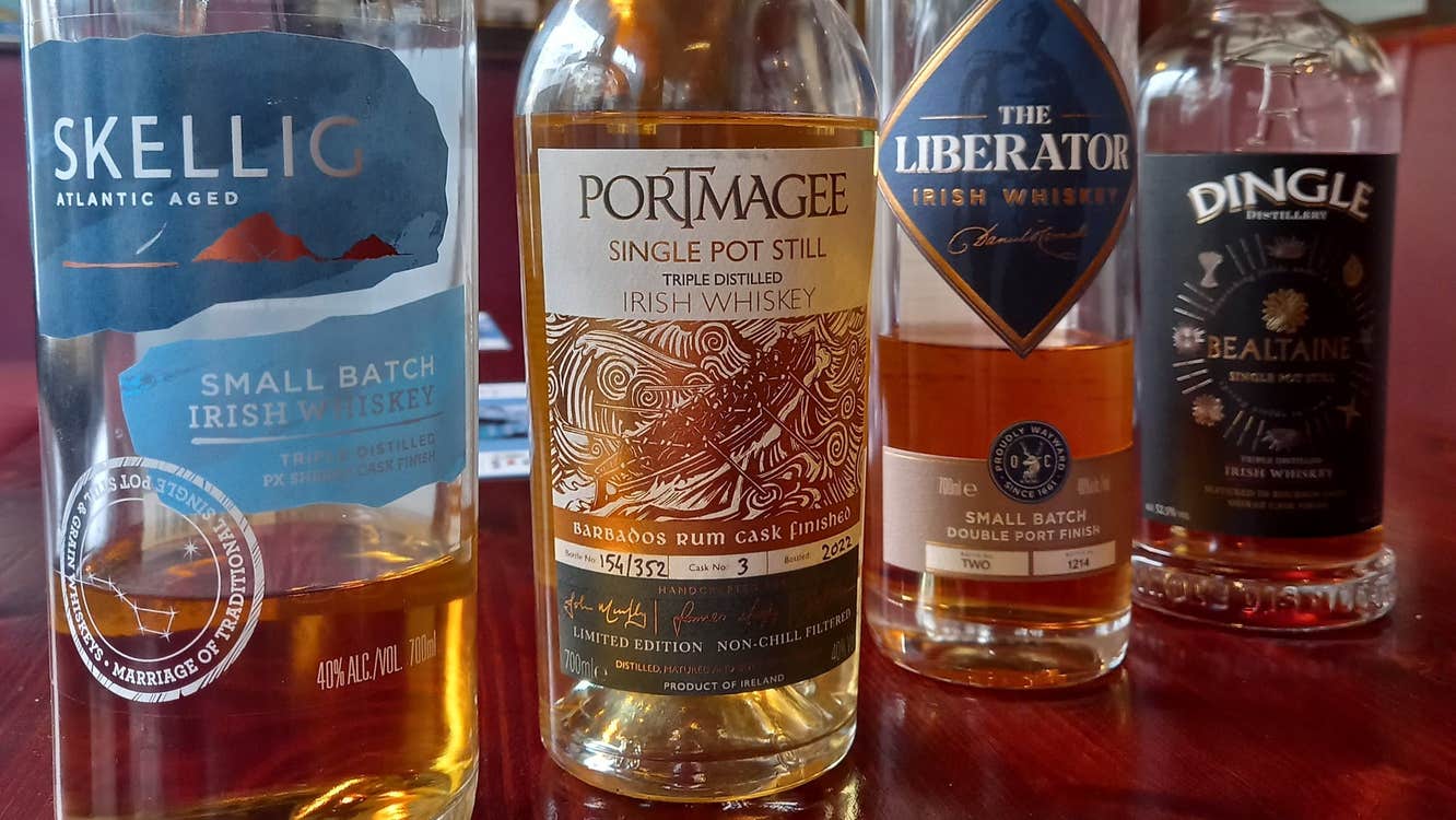 Four whiskey bottles on a wooden counter