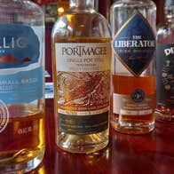 Four whiskey bottles on a wooden counter
