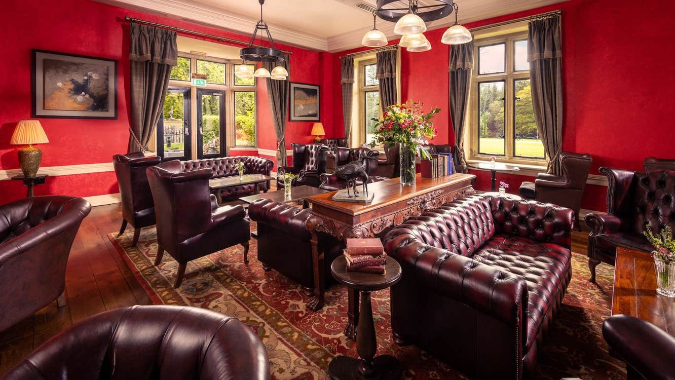 A seating area in a bar with large leather couches and tables