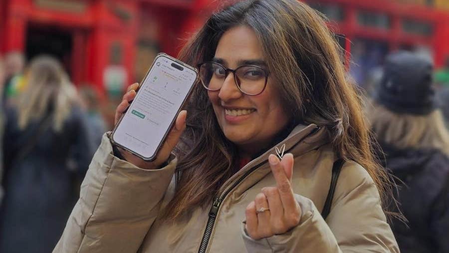 A person holding a phone up so that an app is visible on the screen