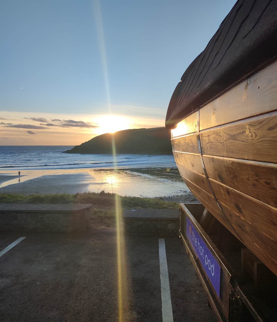 The sunsetting behind a mountain at Kilmurrin Cove in Waterford with The Hot Pod sauna.
