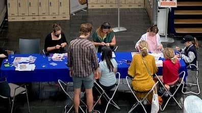 Drop-in for Families: Bealtaine Celebration, a long table with children and adults making things.