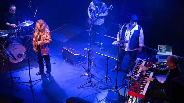 Looking down on a band playing on a small stage, lit with blue light